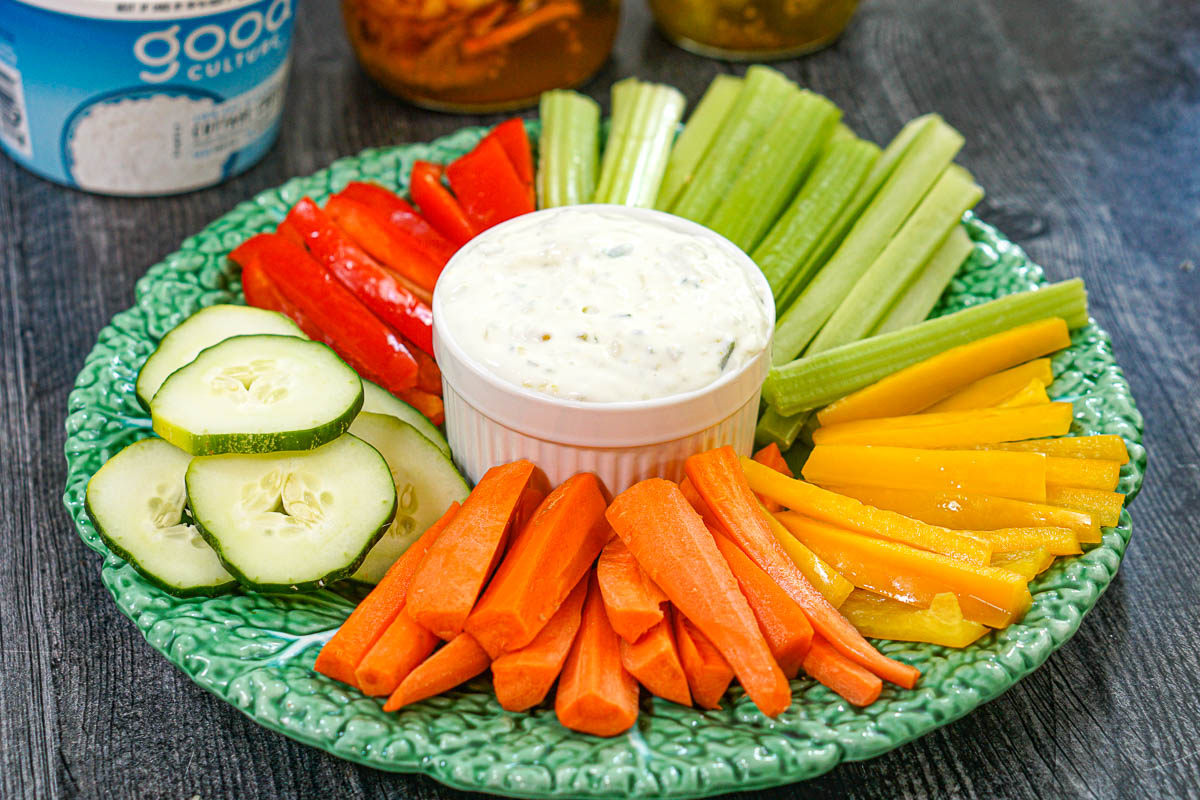 Green platter with veggies and high protein cottage cheese pickle dip.