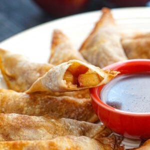 Closeup of an air fryer sugar free apple pie wonton with a bite taken out.