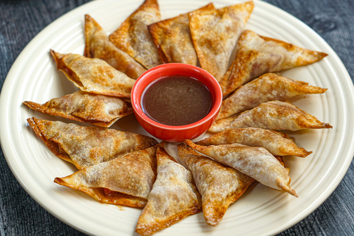 Closeup of the finished dish with a bowl of brown sugar sauce in the middle.