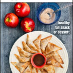 Aerial view of a plate of the apple wontons with a a bowl of cinnamon brown sugar sauce and fresh apples and cinnamon sugar and text overlay.