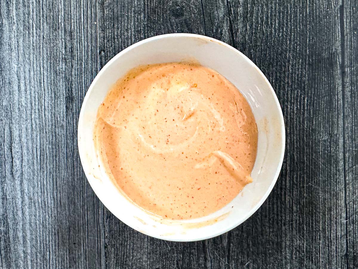 White bowl with spicy mayo sauce.