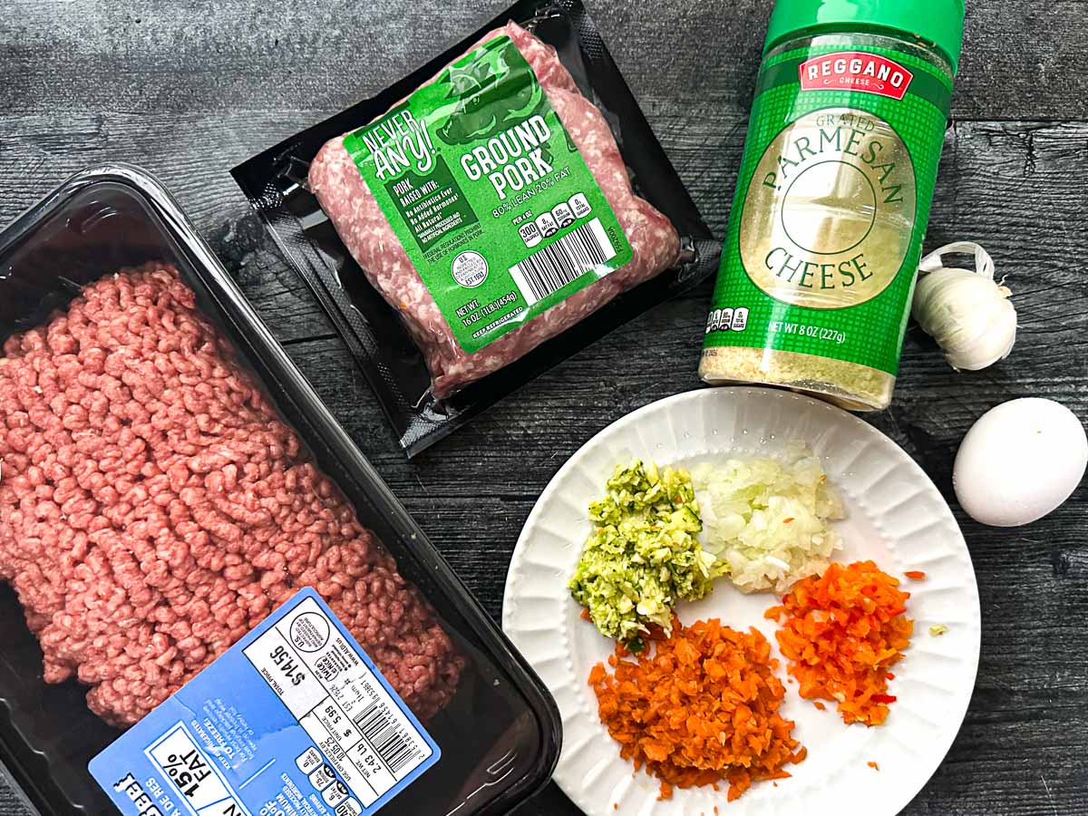 Recipe ingredients - ground beef, ground pork, parmesan cheese, garlic, egg, and minced veggies.