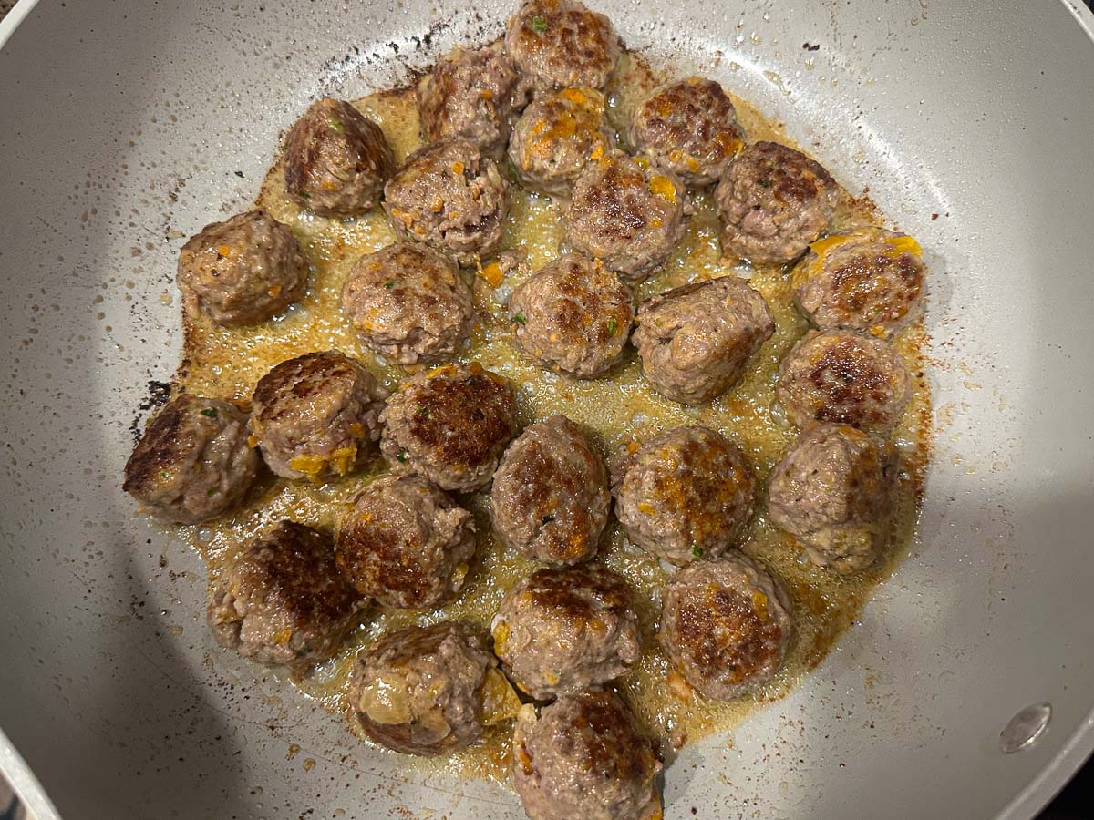 Skillet with browned meatballs.