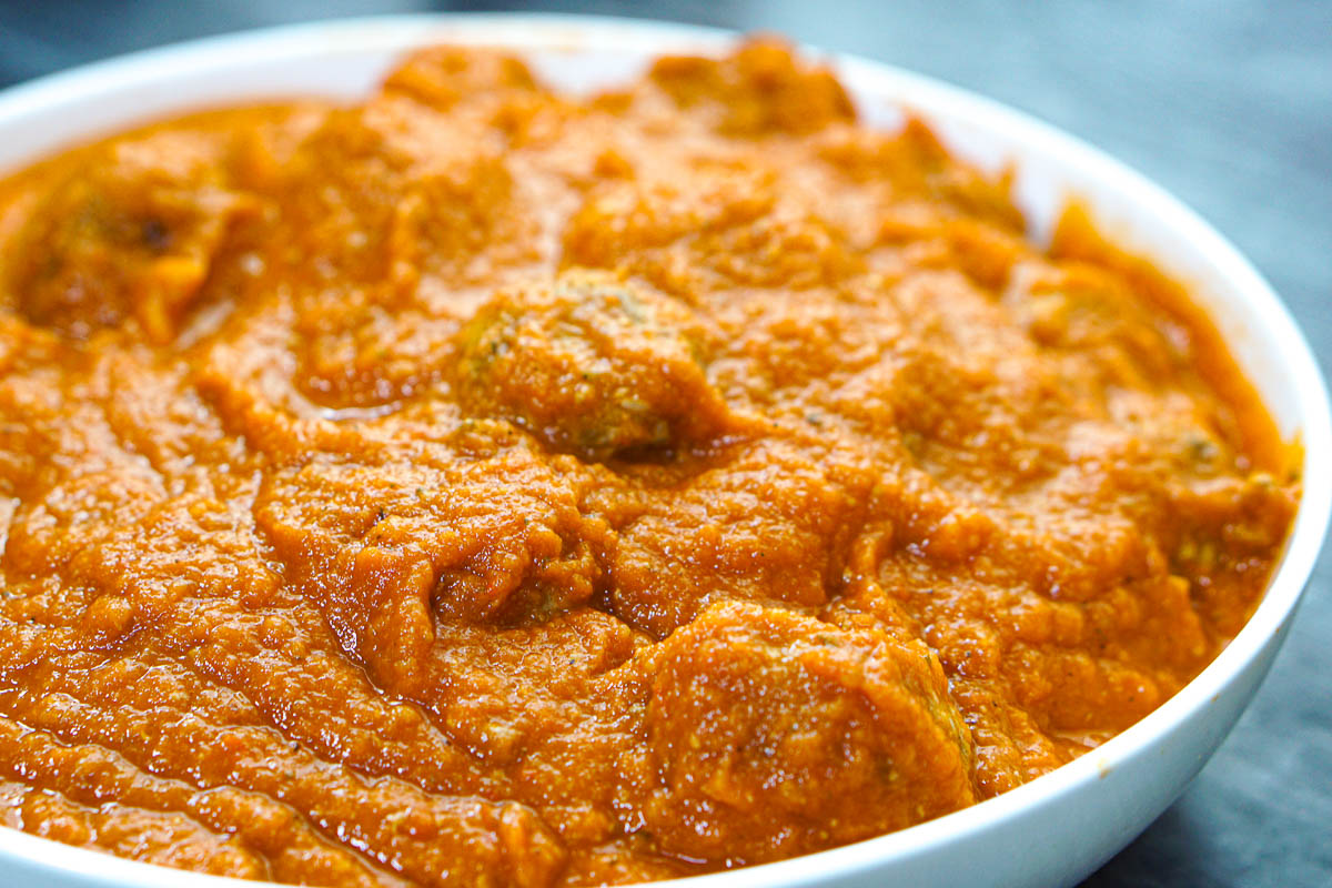 Closeup of a bowl of veggie pasta sauce with the meatballs with veggies in it.