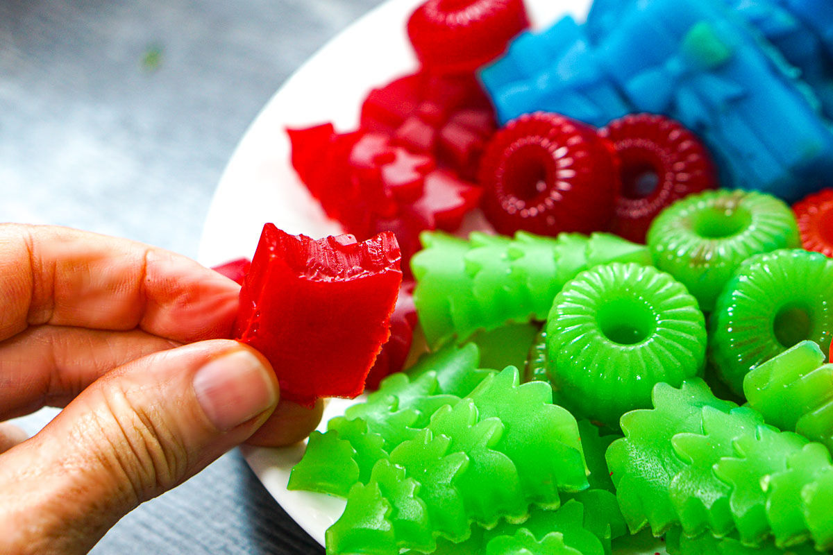 Fingers that hold a piece of keto candy with a bite taken out.