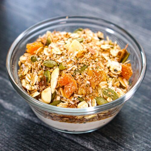 Small glass bowl with yogurt and homemade muesli on top.