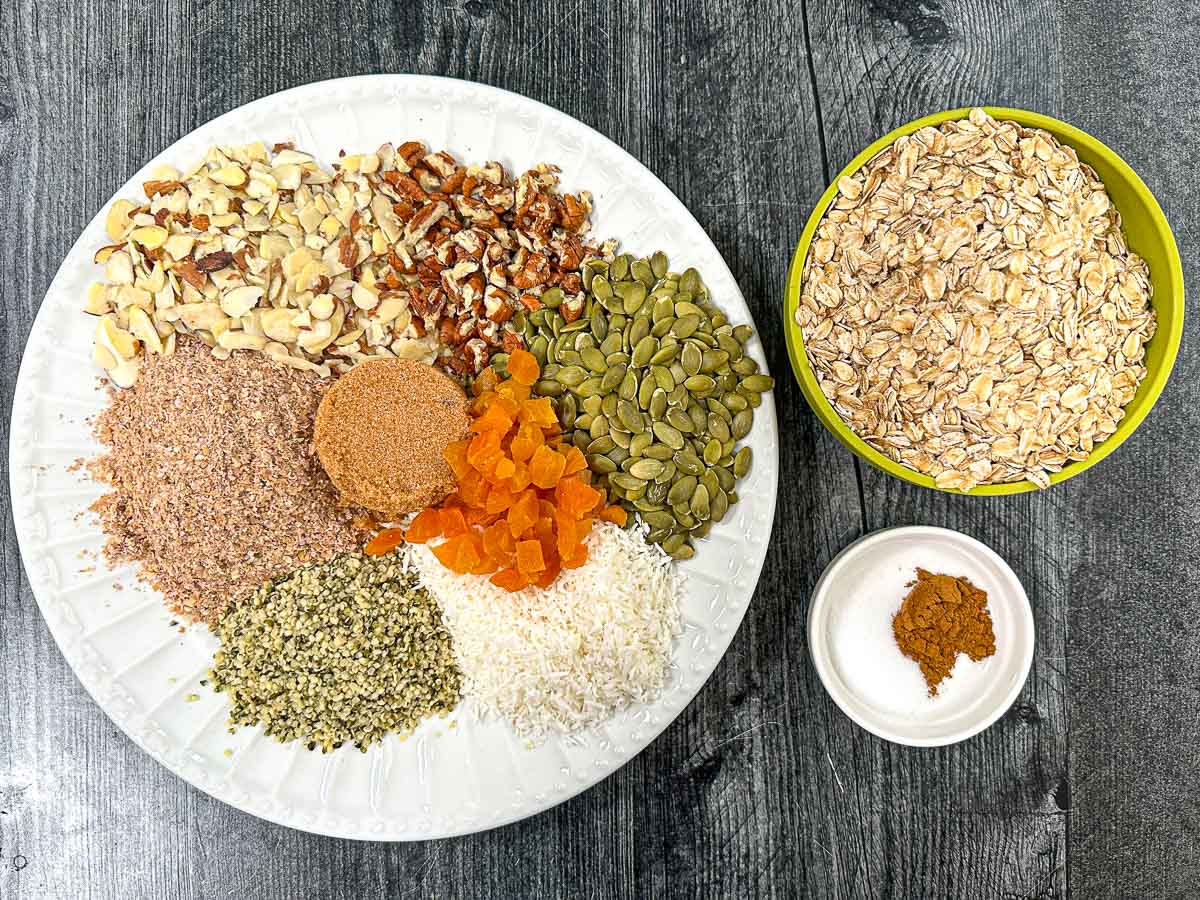 Recipe ingredients - nuts, oatmeal, flax, pepitas, brown sugar, spices, coconut, apricots, hemp seeds