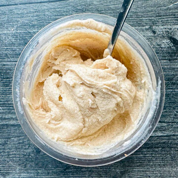 Aerial view of a pint of creamy keto egg nog ice cream and a spoon sticking out.