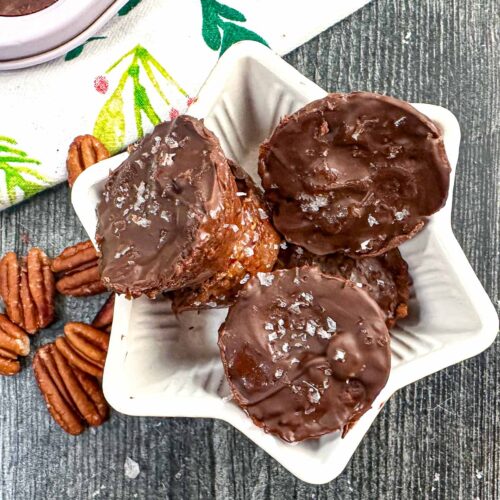 Closeup of white star bowl with keto toffee candy and raw pecans.