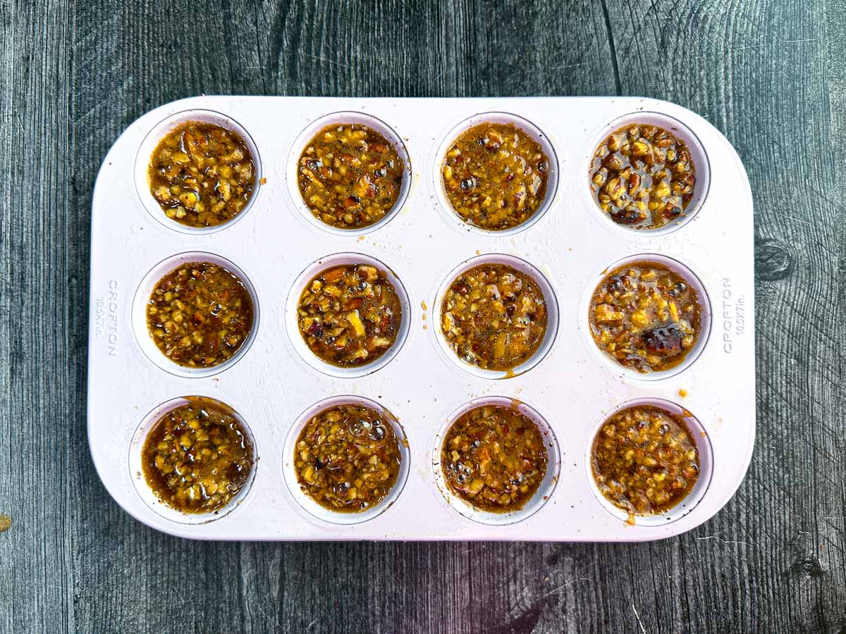 Muffin tin with the chopped nuts layer.