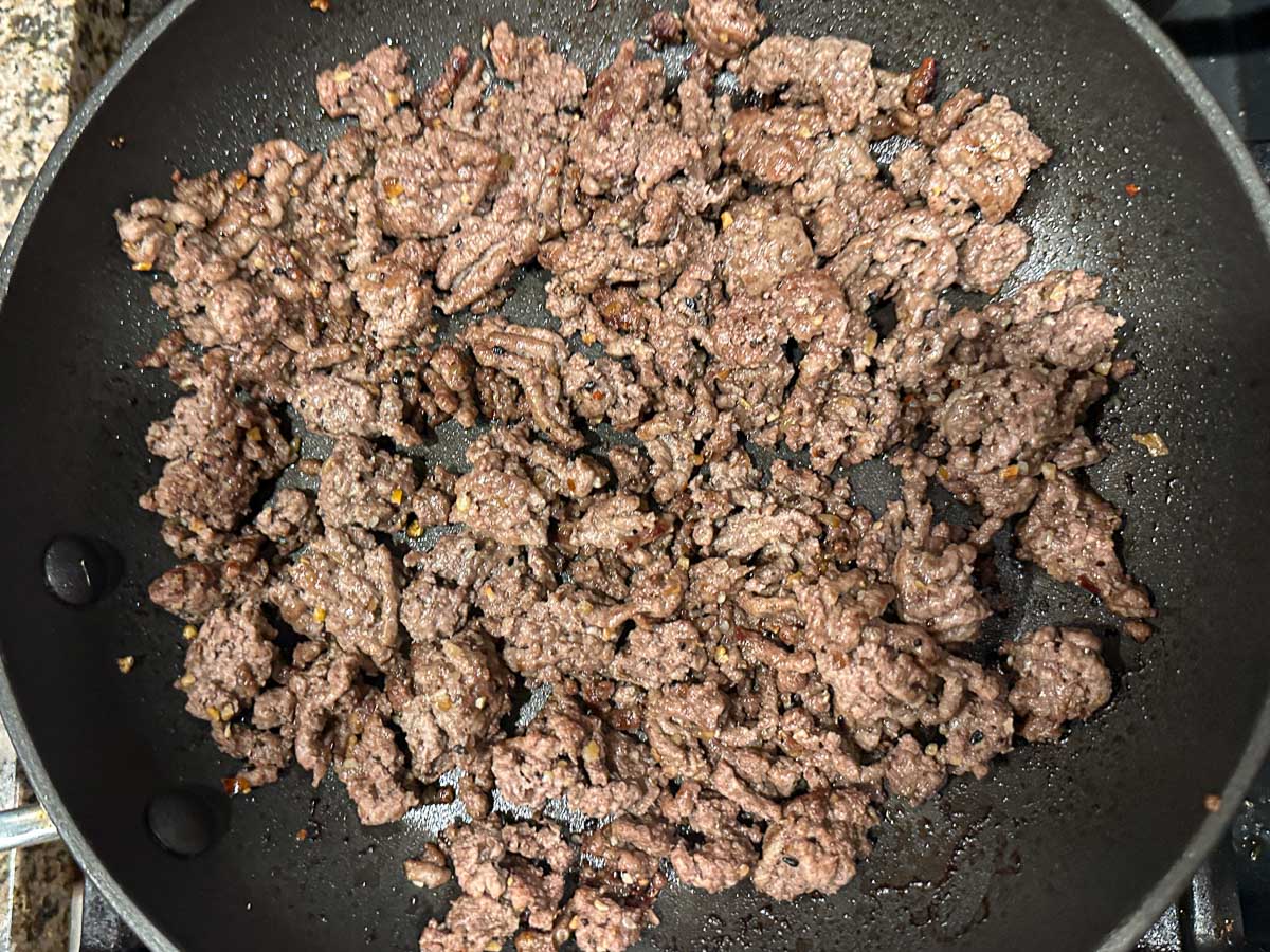 Skillet with browned ground beef.