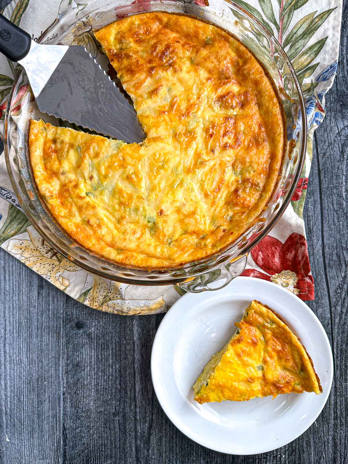 Aerial view of pie plate and white plate with the keto crustless cottage cheese quiche.