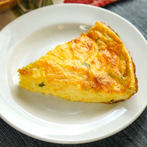 White plate with a piece of the keto crustless cottage cheese quiche.