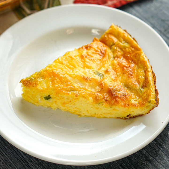 White plate with a piece of the keto crustless cottage cheese quiche.