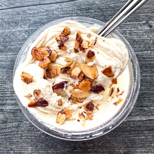 Aerial view of a pint container of low carb high protein Ninja Creami toasted almond ice cream with toasted nuts on top.