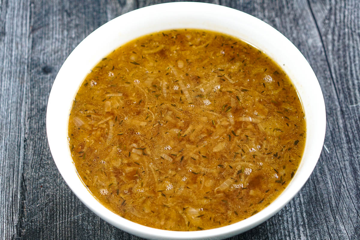 A large white bowl with the finished keto onion soup.