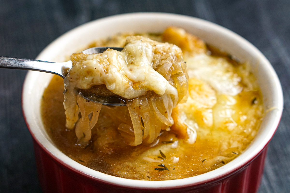 Closeup of a spoonful of low carb cheesy onion soup.