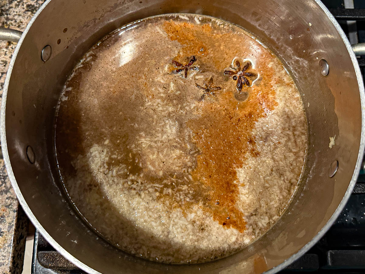 Soup pot with the spices and broth and beef in it.