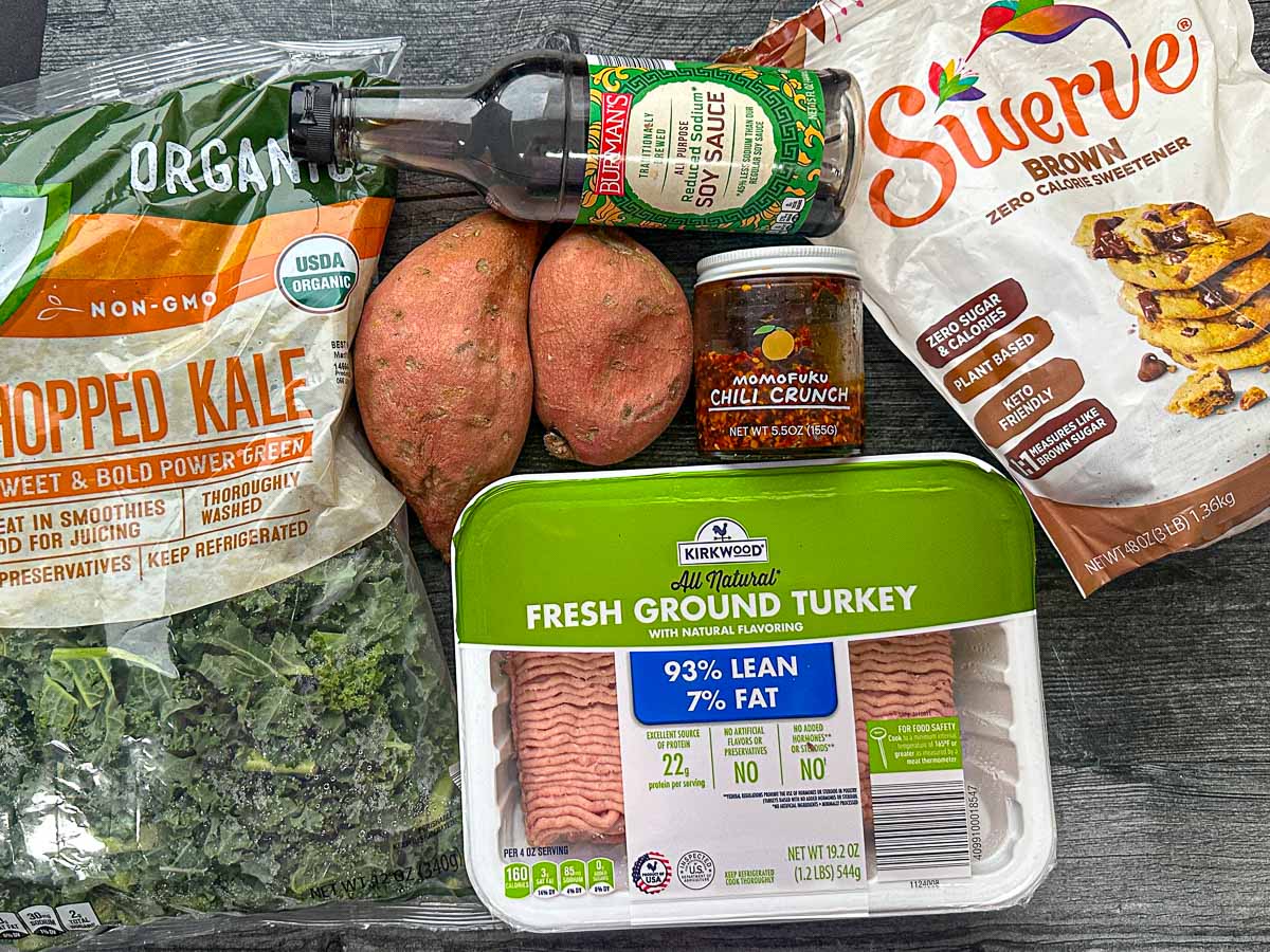 Recipe ingredients - sweet potatoes, kale, soy sauce, ground turkey, Swerve brown sweetener and chili garlic crunch.