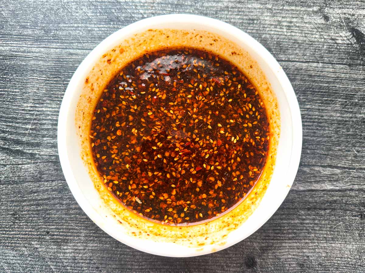 White bowl with the spicy and sweet Asian sauce.