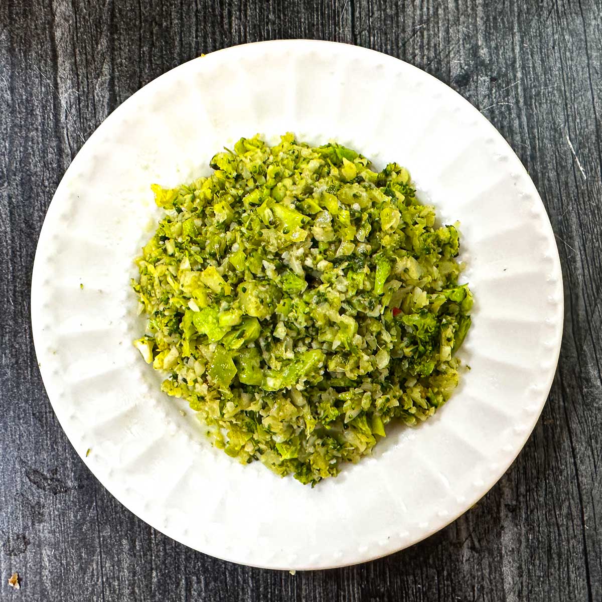 Aerial white plate with the low carb pesto broccoli cauliflower rice.